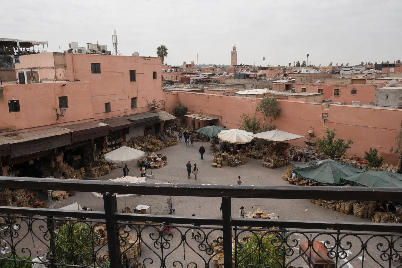 Petite place de marché aux épices de la médina vue depuis un rooftop, parasols et étals en contrebas