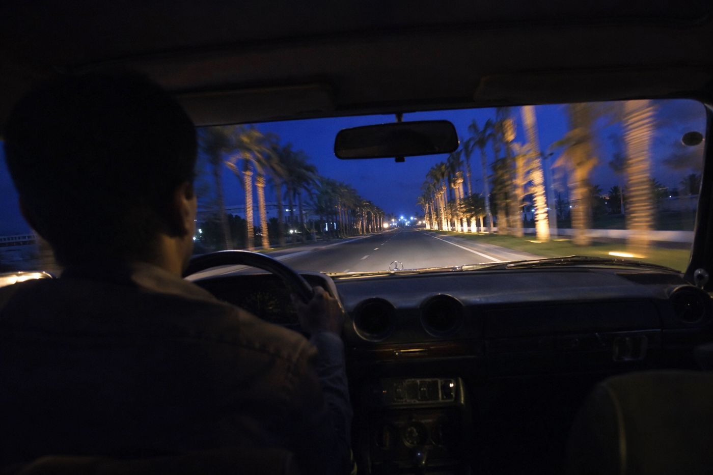 Route de la Palmeraie vue depuis la banquette arrière d'un taxi à la tombée de la nuit