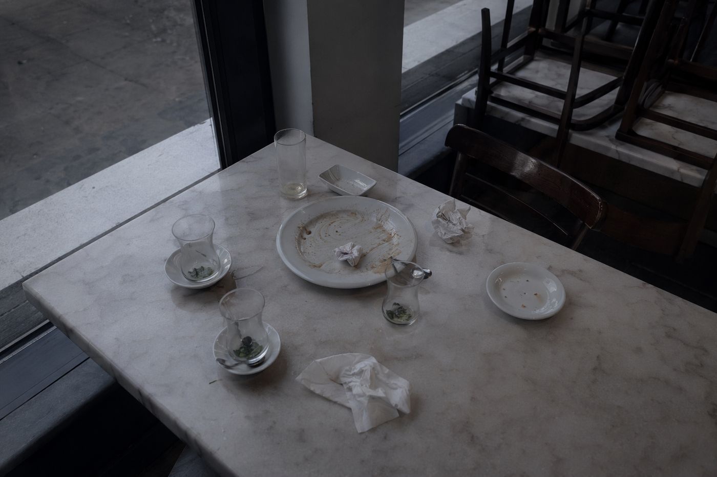 Table de fin de soirée vue de dessus, verres de thé vides et serviettes froissées à la première lueur du jour